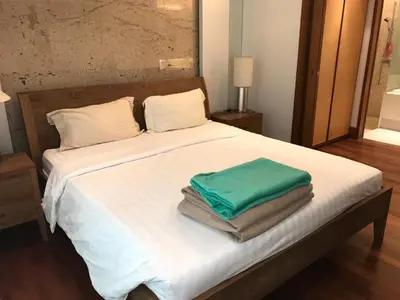 a bed with white sheets and green towels on it at Naithon beach WERT in Phuket Town