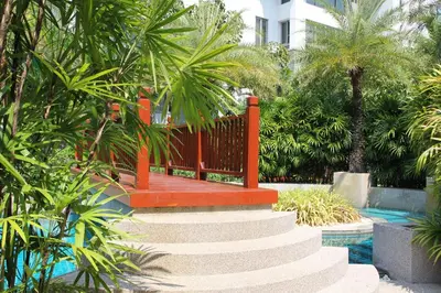 a set of stairs leading to a pool with palm trees at Naithon beach WERT in Phuket Town