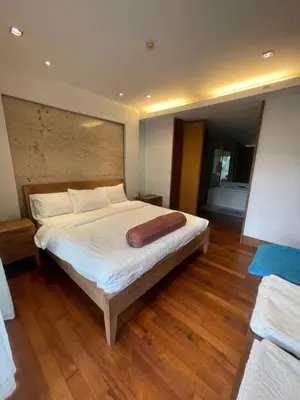 a bedroom with a large bed with a wooden floor at Naithon beach WERT in Phuket Town
