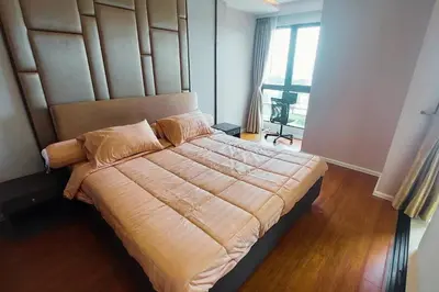 a bedroom with a large bed with a wooden headboard at Seaview Condo In 5 Star Resort MG1 in Phuket Town