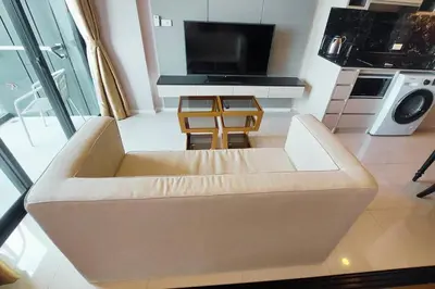 a living room with a couch and a tv at Seaview Condo In 5 Star Resort MG1 in Phuket Town