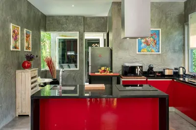 a kitchen with a red and black counter top at VILLA FLORA - North Phuket, Naiyang Beach area in Nai Yang Beach