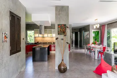 a kitchen and dining room with a vase on the floor at VILLA FLORA - North Phuket, Naiyang Beach area in Nai Yang Beach