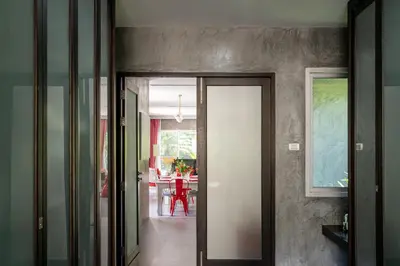 a hallway with a door leading to a dining room at VILLA FLORA - North Phuket, Naiyang Beach area in Nai Yang Beach