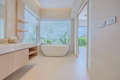 a bathroom with a tub and a large window at The Salin Seaview Villas in Kata Beach