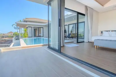 a bedroom with a bed and a pool in a house at The Salin Seaview Villas in Kata Beach
