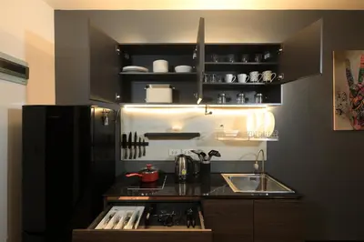 a kitchen with black cabinets and a sink at 1 bdr Apartment Naiharn Beach Condo by CapitalPro in Phuket Town