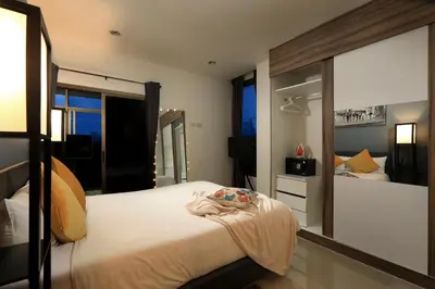 a bedroom with a bed and a large mirror at 1 bdr Apartment Naiharn Beach Condo by CapitalPro in Phuket Town
