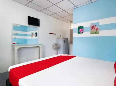 a bedroom with a white bed with a red blanket at THE NAIYANGHOUSE in Nai Yang Beach