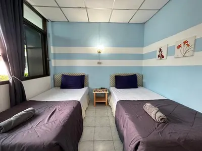 two beds in a room with blue walls at THE NAIYANGHOUSE in Nai Yang Beach