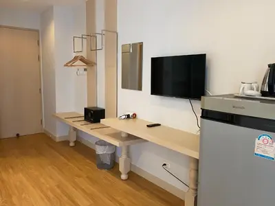 a room with a desk with a television on a wall at Di Yana Patong in Patong Beach