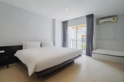 a bedroom with a large white bed and a window at Di Yana Patong in Patong Beach
