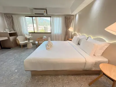 a bedroom with a large white bed and a desk at Upsea patong in Patong Beach