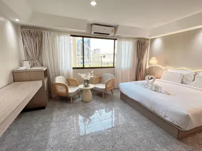 a hotel room with a bed and a table and chairs at Upsea patong in Patong Beach