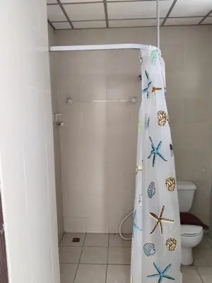 a bathroom with a shower curtain with butterflies on it at Urban Patong Residence in Patong Beach