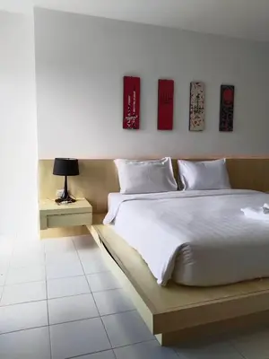 a bedroom with a large bed and a table with a lamp at Urban Patong Residence in Patong Beach