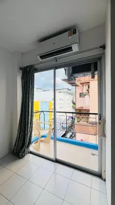 a room with a balcony with a large window at Urban Patong Residence in Patong Beach