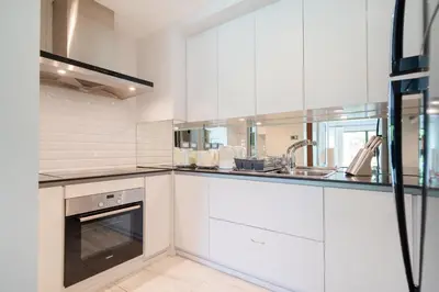 a white kitchen with white cabinets and a sink at Spacious 2BR Apartment ALM 2223 in Laguna, 10 min from BangTao Beach in Bang Tao Beach