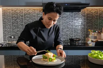 a man preparing a dish on a plate in a kitchen at New 3BR Private Pool Villa with 5 Stars Resort Service in Rawai Beach