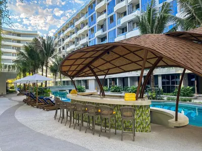 a resort with a table and chairs and a pool at La Green Hotel and Residence in Bang Tao Beach