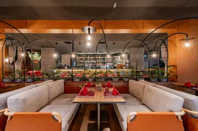 a restaurant with a long couch and a table at La Green Hotel and Residence in Bang Tao Beach