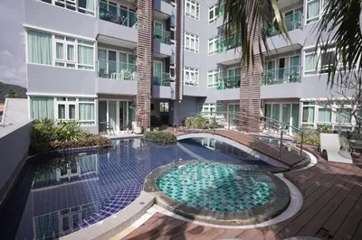 an external view of a building with a swimming pool at Calypso Condo Rawai Nai Harn beach in Rawai Beach