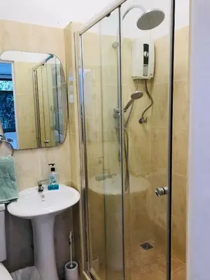 a bathroom with a shower and a sink at Master Bedroom with private bathroom and kitchen in Phuket Town