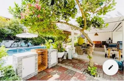 a house with a tree and a swimming pool at Master Bedroom with private bathroom and kitchen in Phuket Town