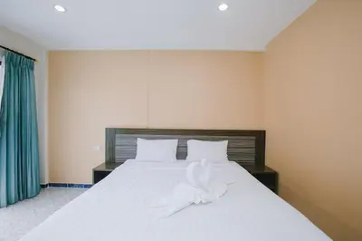 a bedroom with a white bed with a towel on it at O'Shop Residence Patong Beach in Patong Beach