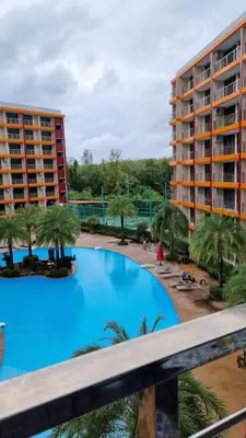 a large swimming pool with palm trees and buildings at CB408 Apartament Beach condo 777 in Phuket Town