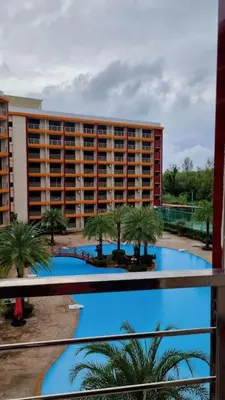 a large building with palm trees and a swimming pool at CB408 Apartament Beach condo 777 in Phuket Town