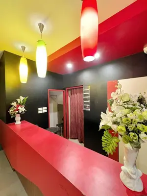 a lobby with a red counter with flowers in a vase at Hangover Aonang in Ao Nang Beach