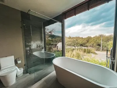 a bathroom with a tub and a glass window at Le Villa Residence in Phuket Town
