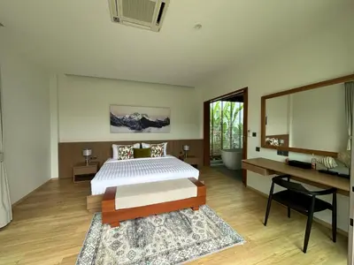 a bedroom with a bed and a desk and a mirror at Lada Pool Villa in Bang Tao Beach