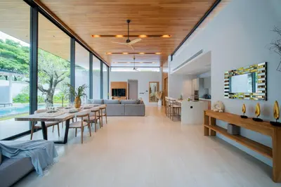 a dining room and living room with large windows at Botanica Foresta 4BR Luxury Villa with Pool by NLA in Bang Tao Beach