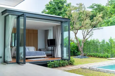 a glass extension of a bedroom with a pool at Botanica Foresta 4BR Luxury Villa with Pool by NLA in Bang Tao Beach