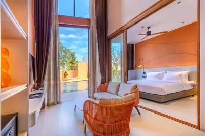 a bedroom with a bed and a chair and a window at Hotel Adam Krabi in Ao Nang Beach