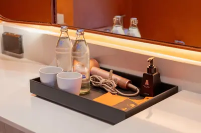 a drawer with two bottles and cups on a counter at Hotel Adam Krabi in Ao Nang Beach
