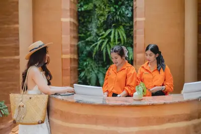 three women standing around a table with a laptop at Hotel Adam Krabi in Ao Nang Beach