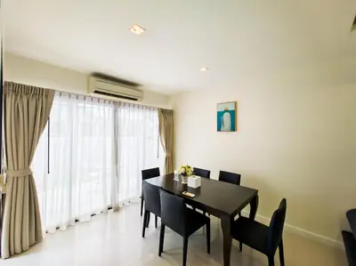a dining room with a black table and chairs at Townhouse in Laguna Park in Phuket Town