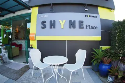 a white table and four chairs in front of a store at Shyne Place in Phuket Town