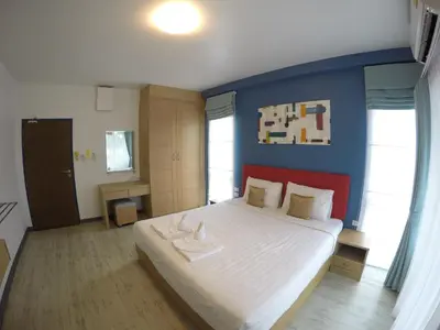 a bedroom with a large bed with a blue wall at Shyne Place in Phuket Town