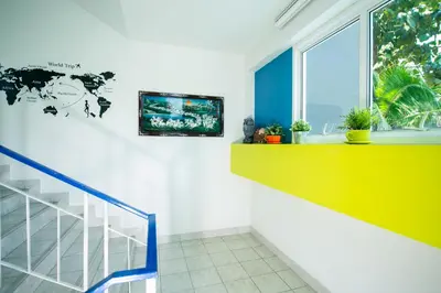 a staircase with a yellow and white wall and a window at Shyne Place in Phuket Town