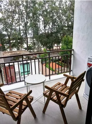 a patio with two chairs and a table on a balcony at The Title Seaview Apartment in Phuket Town