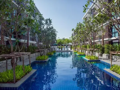 a swimming pool at a resort with trees and buildings at The Title Seaview Apartment in Phuket Town