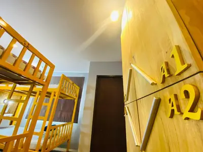 a room with two bunk beds and a clock on a wall at Frutta Hostel in Patong Beach