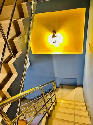 a spiral staircase in a building with a light on the ceiling at Frutta Hostel in Patong Beach