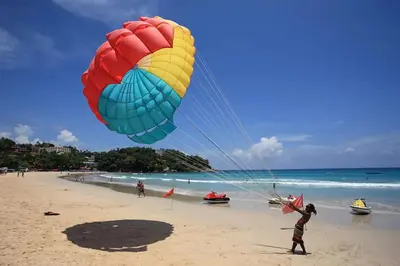a person flying a large kite on a beach at Little Mermaid Guesthouse & Restaurant in Kata Beach