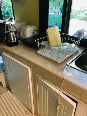 a kitchen counter with a dish drying rack and a sink at Guest House, shared pool, private bathroom and kitchen in Phuket Town
