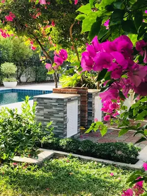 a garden with pink flowers and a swimming pool at Guest House, shared pool, private bathroom and kitchen in Phuket Town